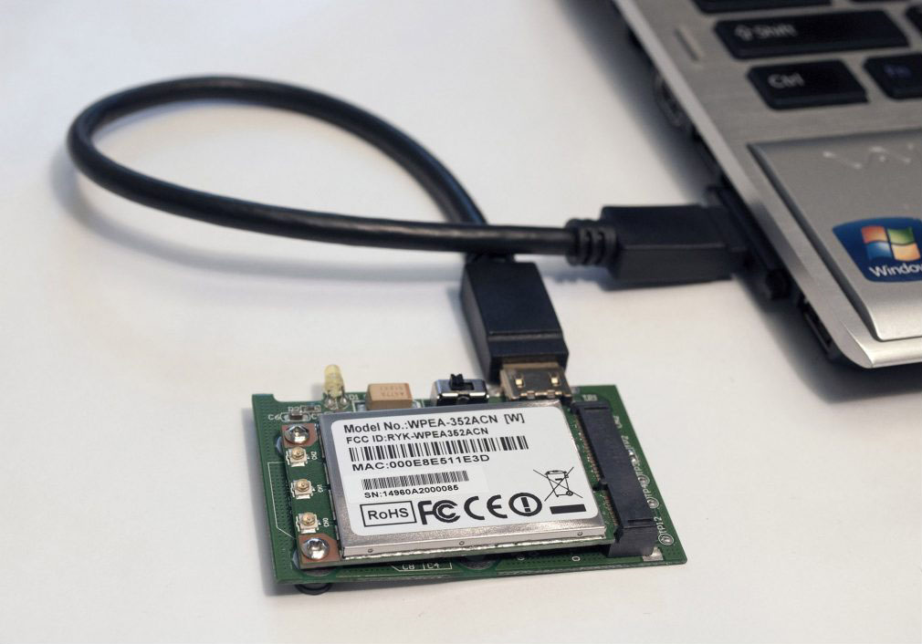 The board is connected to a laptop; the ExpressCard is plugged into the laptop.